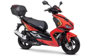Czerwony skuter Romet z czarnym siedzeniem i kufrem. Idealny do miasta, do jakiej pojemności można jeździć motorem bez prawa jazdy?