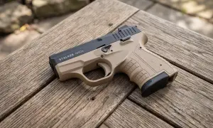 Beżowa broń pneumatyczna Stalker M906 leży na drewnianym stole.