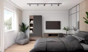 Nowoczesny pokój młodego mężczyzny z szarą pufą, regałem, telewizorem i łóżkiem.