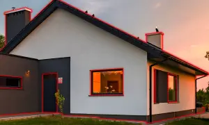 Maison moderne avec contours rouges. Une porte sombre, des fenêtres éclairées. Idéal pour choisir son alarme et sécuriser son domicile.