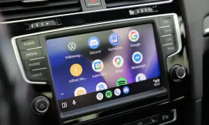 Ekran samochodu z ikonami aplikacji: Volkswagen, Discord, Mapy, Google, Messenger. Widoczne są też przyciski Radio, Media, Phone, Voice. To są android auto ustawienia.