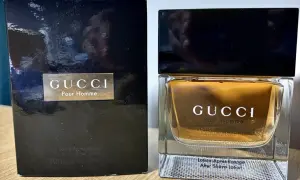Elegancki zestaw z wodą po goleniu Gucci Pour Homme. Złocisty płyn w szklanym flakonie i czarne opakowanie.
