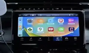 Ekran samochodu z ikonami aplikacji, w tym nawigacją i muzyką. To właśnie co to jest CarPlay – integracja telefonu z autem.