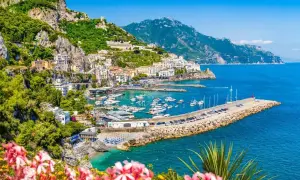 Malowniczy widok na wybrzeże Amalfi, idealne miejsce na neapol na weekend. Woda lśni, a domy wspinają się po zboczu.