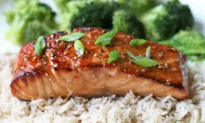 Łosoś w sosie teriyaki z ryżem i brokułami, posypany sezamem i szczypiorkiem.