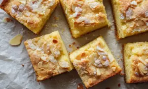 Saftiger Buttermilchkuchen vom Blech, bestreut mit Mandelblättchen und Puderzucker. Ein Genuss für jeden Kaffeetisch.