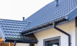 Szary dach z dachówki ceramicznej, idealny do obliczenia dachówka ceramiczna cena za m2. System rynnowy odprowadza wodę.
