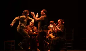 Artistas de flamenco, con guitarras y palmas, dan vida a la escena. El significado de "jalear" se siente en la energía.