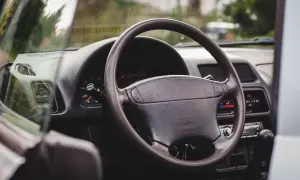 Wnętrze Suzuki X90: kierownica, deska rozdzielcza z zegarami i radiem, widok z perspektywy kierowcy.