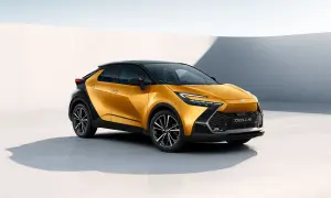 Nowy, lśniący, żółty Toyota C-HR z czarnym dachem prezentuje się dynamicznie na tle minimalistycznej architektury.