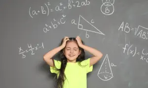 Dziewczynka z rękami wplątanymi we włosy, wyraźnie przeżywająca problemy z matematyką. Wokół niej wzory i figury geometryczne na tablicy.
