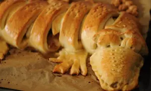 Złociste, pieczone krokodylki z ciasta, z widocznymi łuskami i łapkami, wyglądają apetycznie.