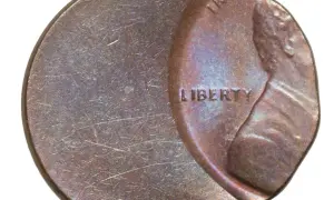 Zniszczona moneta z napisem "LIBERTY". Widać ślady użytkowania i drobne uszkodzenia.