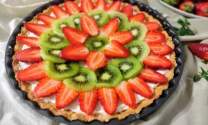 Tarta z mascarpone ozdobiona słodkimi truskawkami i soczystym kiwi. Pyszny deser na każdą okazję.