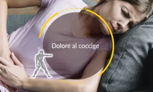 Donna con dolore al coccige, che cerca rimedi della nonna per alleviare il fastidio.