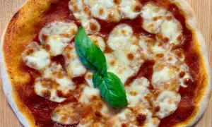 Eine köstliche italienische Sauerteig Pizza Margherita mit geschmolzenem Mozzarella und frischem Basilikum.
