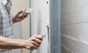 Un artisan applique un enduit de finition sur un mur avec une truelle, préparant la surface pour une peinture parfaite.