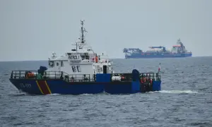 Kuter Straży Granicznej "PATROL 1" płynie po morzu. W tle widać duży statek "Van Oord".