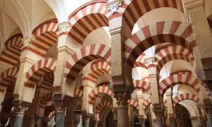 Las icónicas partes de la mezquita de Córdoba: arcos de herradura bicolores y columnas que crean un laberinto arquitectónico.