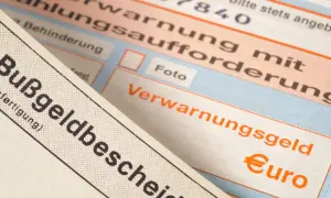 Zbliżenie na niemieckie mandaty, w tym "Bußgeldbescheid" i "Verwarnungsgeld" z symbolem euro.