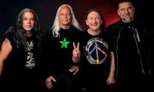Czterech mężczyzn w czarnych ubraniach, tworzących TSA dream team. Jeden pokazuje znak pokoju, inny ma zieloną gwiazdę.