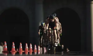 Athletes compete in an Olympic triathlon cycling race, focused and determined as they push forward.