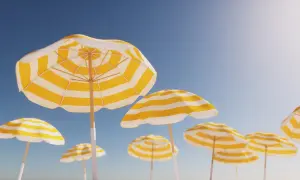 Gula och vita parasoller mot en klarblå himmel, en perfekt bild av arbetsfria dagar.