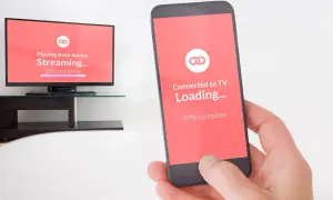 Jak udostępnić ekran z telefonu na telewizor? Widok telefonu i telewizora z ekranem ładowania połączenia.