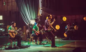 Zespół Mrozu na scenie MTV Unplugged. Wokalista śpiewa, gitarzyści grają, a perkusista wybija rytm.