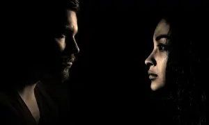 Profili di un uomo e una donna si fronteggiano nel buio, un'immagine che evoca il silenzio dopo la fine di una storia.