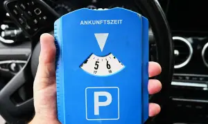 Blaue Parkscheibe mit "Ankunftszeit" und "P"-Symbol. Beachten Sie die Parkuhr Regeln für die korrekte Einstellung der Ankunftszeit.