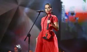 Mery Spolsky na koncercie w czerwonej sukni, trzymająca czerwoną gitarę elektryczną.