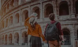 Ett par håller hand framför Colosseum i Rom. Trots att det är december är temperaturen behaglig för turister.