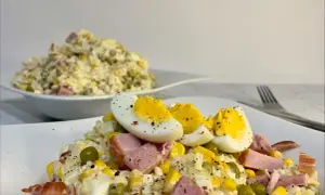 Szybka sałatka z ryżem i jajkiem, z dodatkiem kukurydzy, groszku i szynki, idealna na szybki lunch.