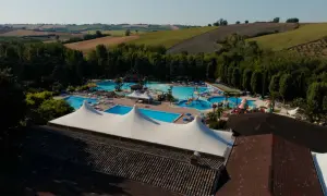 Vasta area con piscine, scivoli e aree relax nel parco acquatico di Cingoli, immerso nel verde delle colline marchigiane.