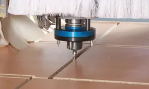 Głowica frezująca CNC precyzyjnie wycina linie na płycie, optymalizując materiał dzięki technice cnc nesting.