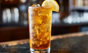 Ett glas Long Island Iced Tea med is och en citronskiva, redo att avnjutas vid en bar.