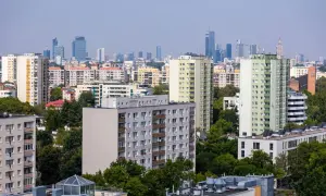 Widok na osiedle mieszkaniowe z blokami i wieżowcami w tle. Zastanawiasz się, jak ubezpieczyć mieszkanie?