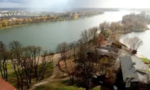 Malownicze jeziora kujawsko pomorskie jesienią. Woda, drzewa bez liści, ścieżki i zabudowania tworzą spokojny krajobraz.