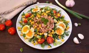Bunter Thunfischsalat mit Eiern, Mais und Tomaten, garniert mit Frühlingszwiebeln. Ein leichter und gesunder Thunfischsalat.