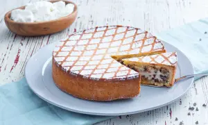 Une délicieuse cassata al forno, saupoudrée de sucre glace, avec une part coupée pour révéler sa garniture crémeuse et chocolatée.