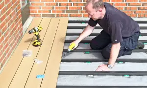 Man monterar komposittrall med skruvdragare. Ett vanligt problem med komposittrall är att det kan vara svårt att få jämna mellanrum.