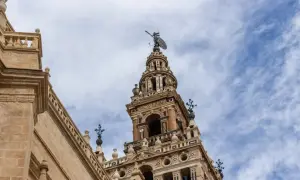 Wspaniała wieża w **Sevilla miasto** z figurą na szczycie i napisem "PROVERBIO".