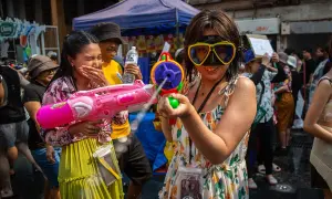 Tajlandia ludność bawi się na festiwalu Songkran, strzelając do siebie z pistoletów na wodę.