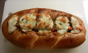 En gyllene, fylld fransk baguette med smält ost och örter.