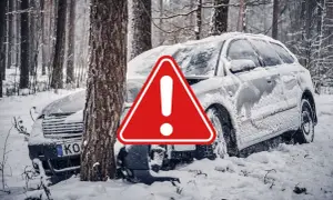 Snöig skogsväg, en bil har kört av vägen och krockat med ett träd. Varningstriangel syns. Fyrhjulsdrift eller inte, snö är en utmaning.