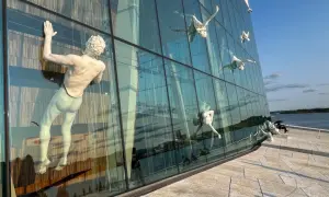 Figury wspinające się po szklanej fasadzie Opery w Oslo.