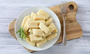 Talerz pełen kopytek z ziemniaków, idealna odmiana do tego dania. Obok widelec i gałązka rozmarynu.