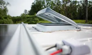 Otwarty wyłaz dachowy na białym dachu kampera, obok paneli słonecznych. Czy wyłaz dachowy jest obowiązkowy?