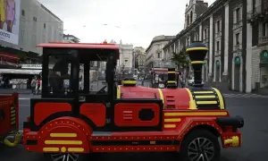 Czerwony pociąg turystyczny na ulicach Katanii Syrakuzy, idealny do zwiedzania.